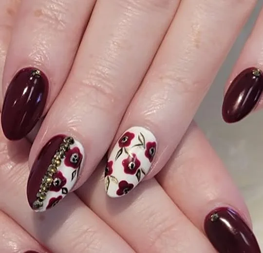 Cherry red nails with silver glitter and heart accents